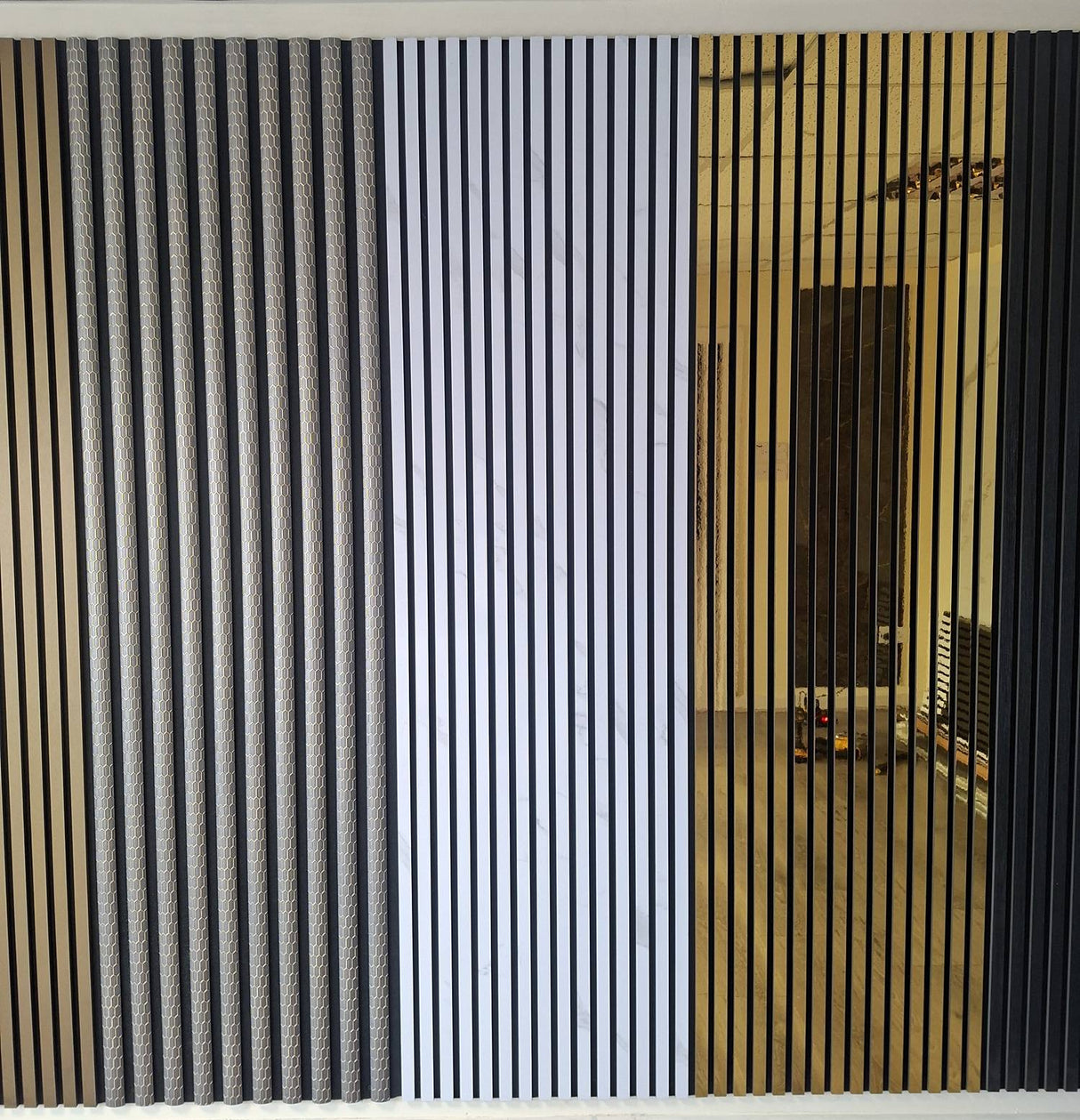 Vertical slat wall panels shown in three color options: black, white, and natural wood, installed on a partition wall in an office interior.