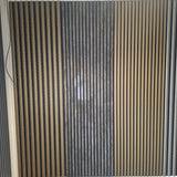 A wall-mounted decorative slatted panel with vertical wood-look and dark textured stripes, installed in a room with a white ceiling and gray floor. A small 'Galaxy A56 5G' watermark is visible at the bottom left.