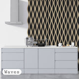 A modern kitchen scene with a white countertop and light gray lower cabinets, set against a black wall covered in a beige wavy pattern. A small espresso machine and cups sit on the counter.