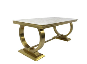 Dining table with marble top and gold metal base on a white background