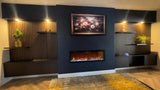 A modern living room interior featuring a dark navy blue accent wall with a built-in linear fireplace, a framed floral painting above it, and symmetrical wood slat shelving with warm lighting and small plants.